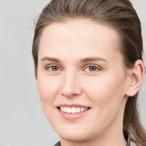 Joyful white young-adult female with medium  brown hair and grey eyes