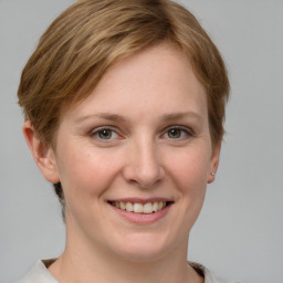 Joyful white young-adult female with short  brown hair and grey eyes