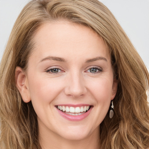 Joyful white young-adult female with long  brown hair and blue eyes