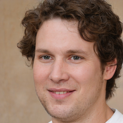 Joyful white adult male with medium  brown hair and brown eyes