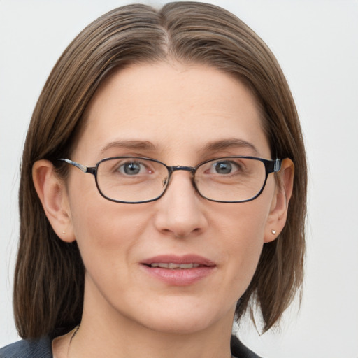 Joyful white adult female with medium  brown hair and grey eyes