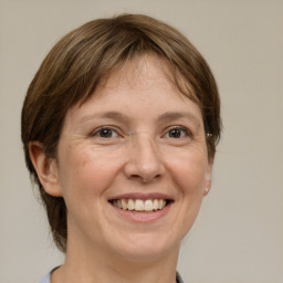 Joyful white adult female with medium  brown hair and grey eyes