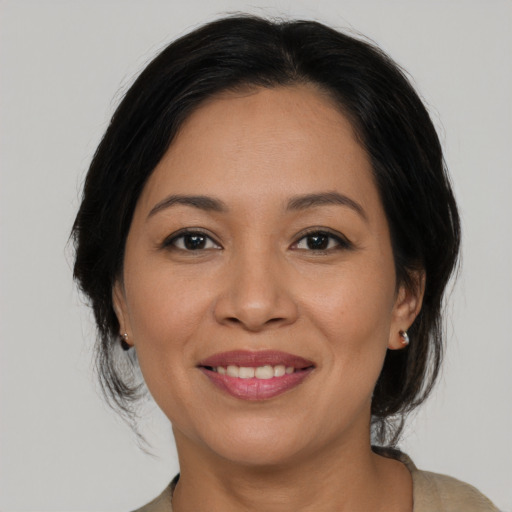 Joyful latino young-adult female with medium  black hair and brown eyes