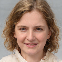 Joyful white young-adult female with medium  brown hair and blue eyes