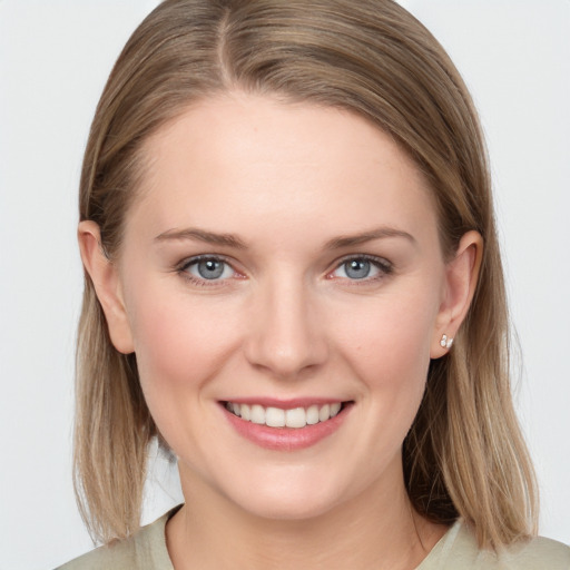 Joyful white young-adult female with long  brown hair and blue eyes