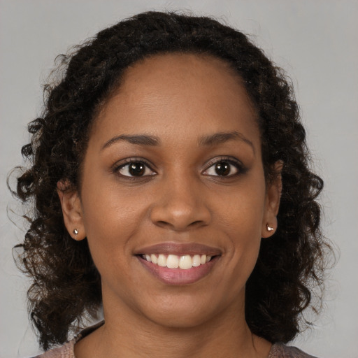 Joyful black young-adult female with medium  brown hair and brown eyes