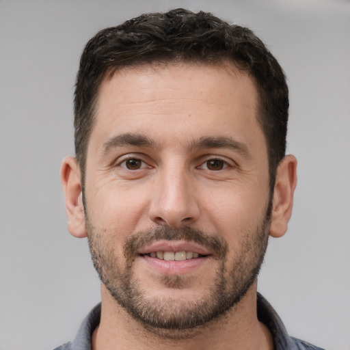 Joyful white young-adult male with short  brown hair and brown eyes