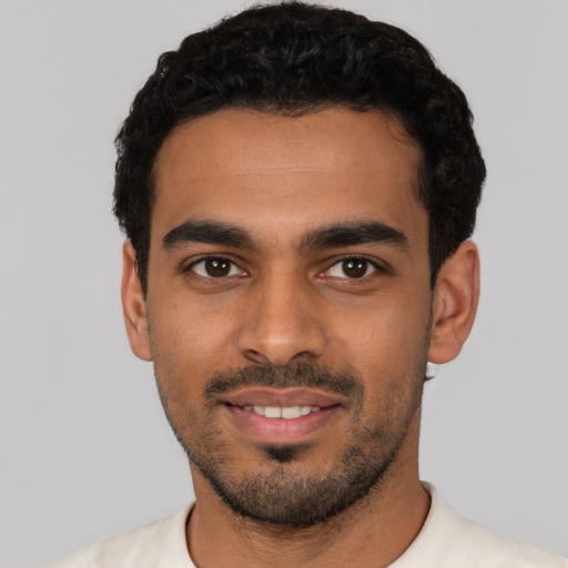 Joyful latino young-adult male with short  black hair and brown eyes