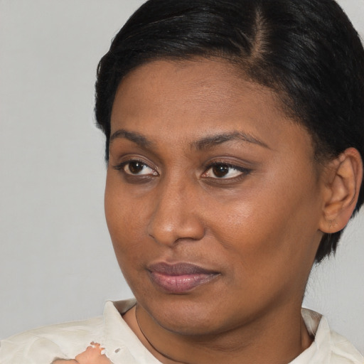 Joyful black young-adult female with short  brown hair and brown eyes