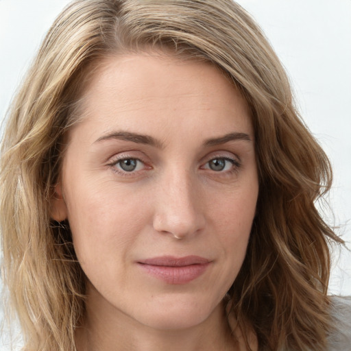 Joyful white young-adult female with long  brown hair and blue eyes