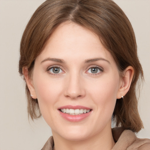 Joyful white young-adult female with medium  brown hair and green eyes