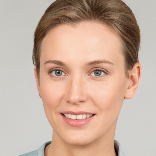 Joyful white young-adult female with short  brown hair and grey eyes