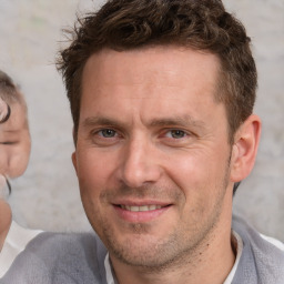 Joyful white adult male with short  brown hair and brown eyes