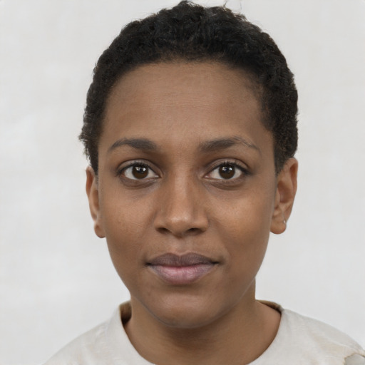 Joyful black young-adult female with short  black hair and brown eyes