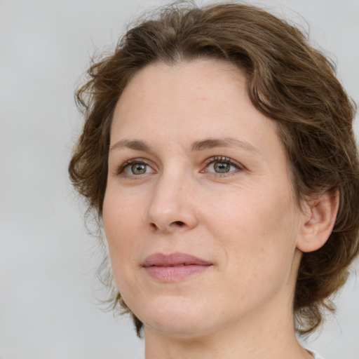 Joyful white adult female with medium  brown hair and green eyes