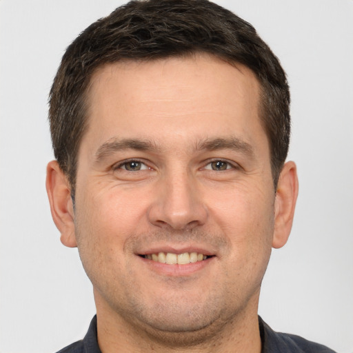 Joyful white adult male with short  brown hair and brown eyes