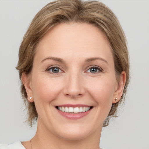 Joyful white adult female with medium  brown hair and grey eyes