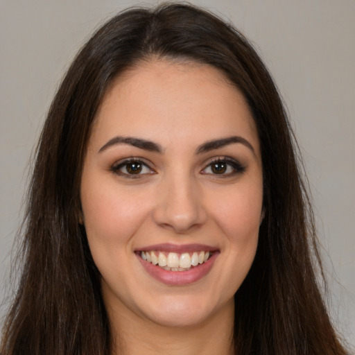 Joyful white young-adult female with long  brown hair and brown eyes