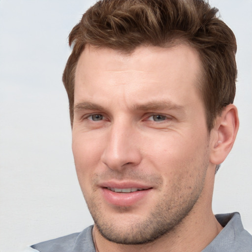 Joyful white young-adult male with short  brown hair and grey eyes