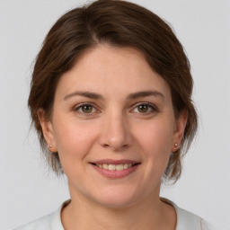 Joyful white young-adult female with medium  brown hair and grey eyes