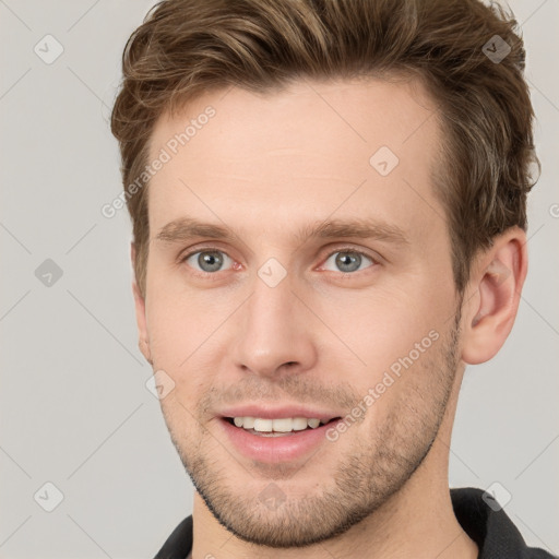 Joyful white young-adult male with short  brown hair and grey eyes