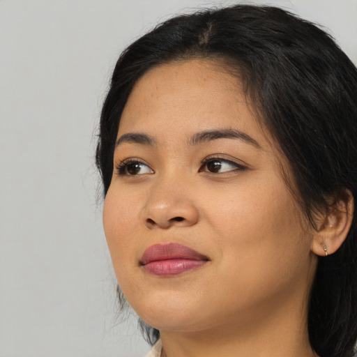 Joyful asian young-adult female with long  black hair and brown eyes