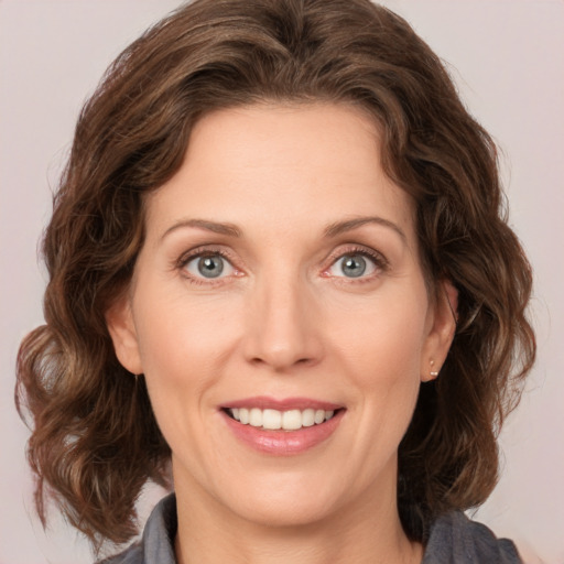 Joyful white young-adult female with medium  brown hair and green eyes