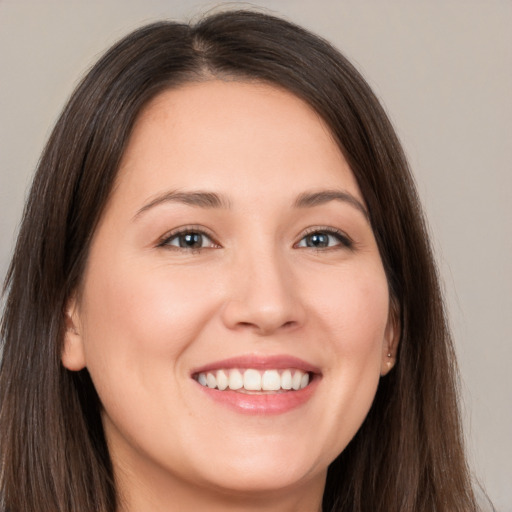 Joyful white young-adult female with long  brown hair and brown eyes