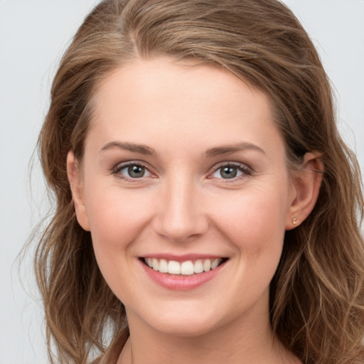 Joyful white young-adult female with long  brown hair and grey eyes