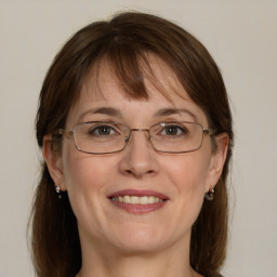 Joyful white adult female with medium  brown hair and blue eyes