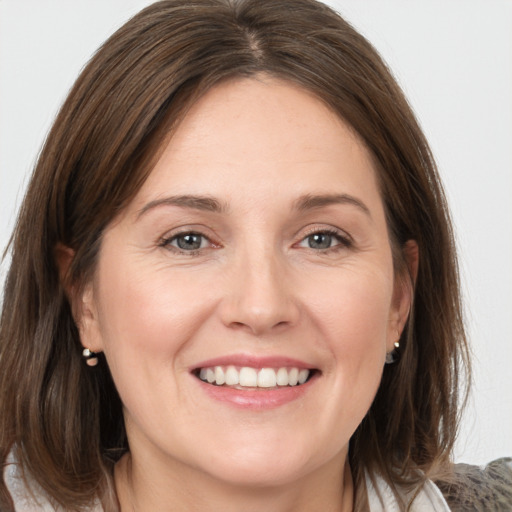 Joyful white young-adult female with medium  brown hair and grey eyes