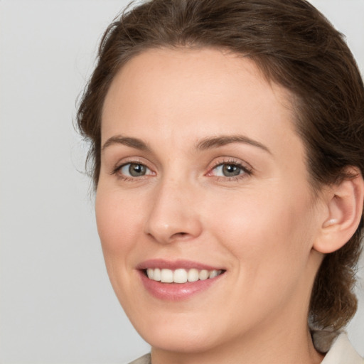 Joyful white young-adult female with medium  brown hair and green eyes