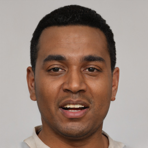 Joyful black young-adult male with short  black hair and brown eyes