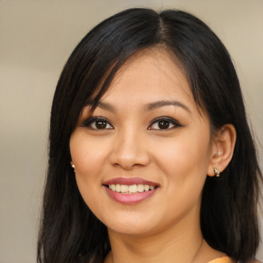 Joyful latino young-adult female with long  brown hair and brown eyes