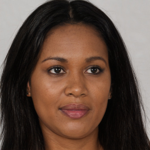Joyful black young-adult female with long  brown hair and brown eyes