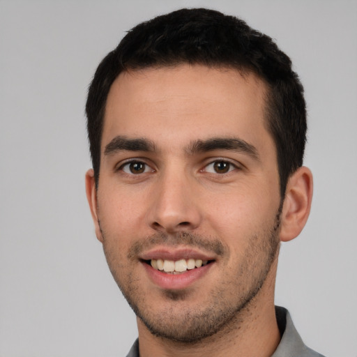 Joyful white young-adult male with short  black hair and brown eyes