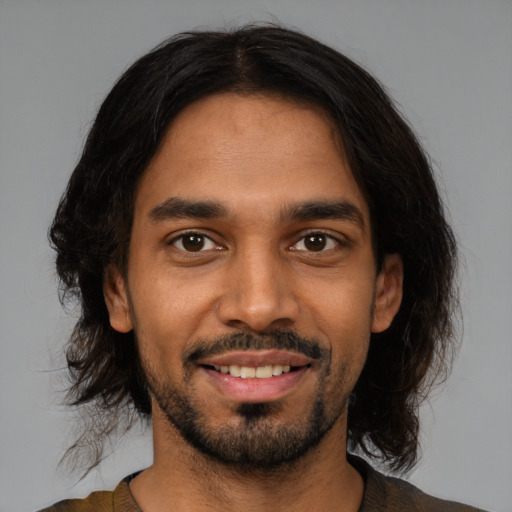 Joyful black young-adult male with medium  black hair and brown eyes