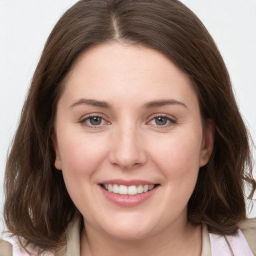 Joyful white young-adult female with medium  brown hair and grey eyes