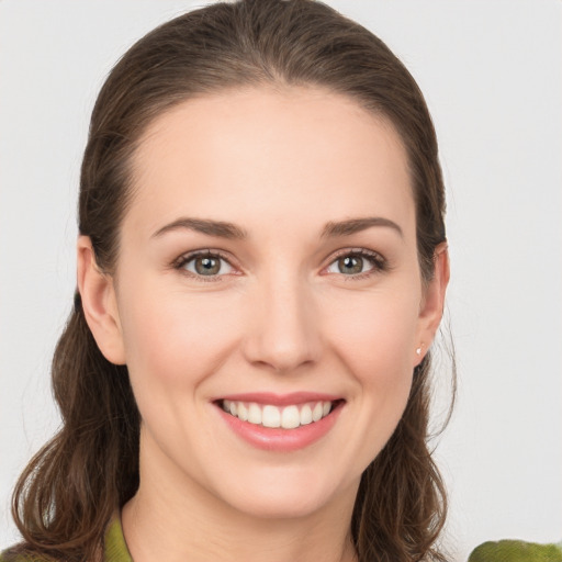 Joyful white young-adult female with medium  brown hair and grey eyes