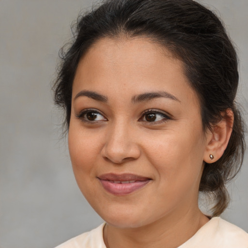 Joyful latino young-adult female with medium  brown hair and brown eyes