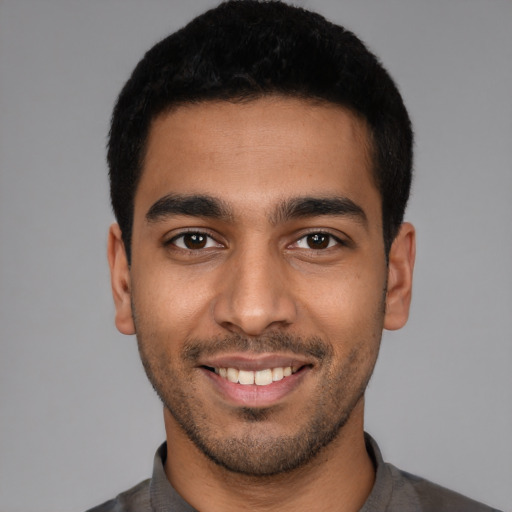 Joyful latino young-adult male with short  black hair and brown eyes
