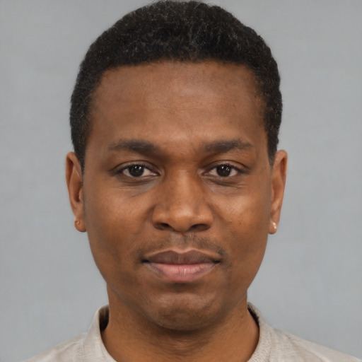 Joyful black young-adult male with short  black hair and brown eyes