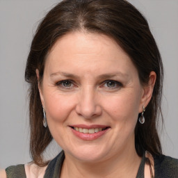 Joyful white adult female with medium  brown hair and grey eyes