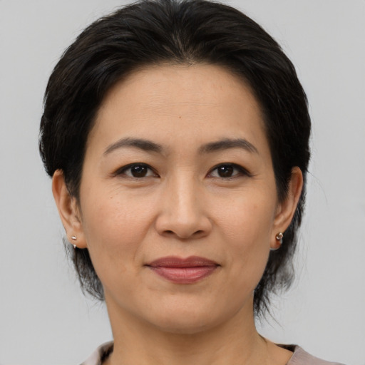 Joyful asian adult female with medium  brown hair and brown eyes