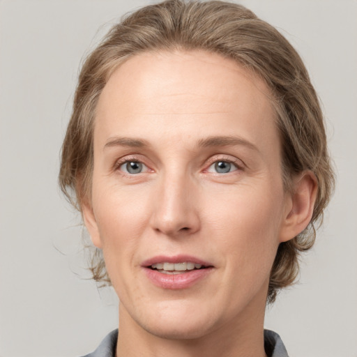 Joyful white adult female with medium  brown hair and grey eyes