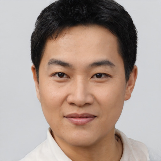 Joyful asian young-adult male with short  black hair and brown eyes