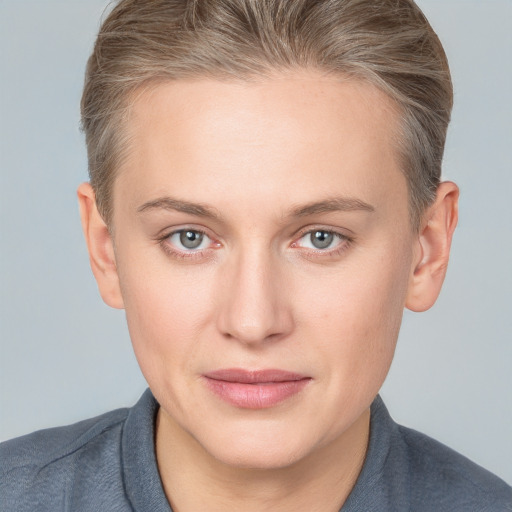 Joyful white young-adult female with short  brown hair and blue eyes