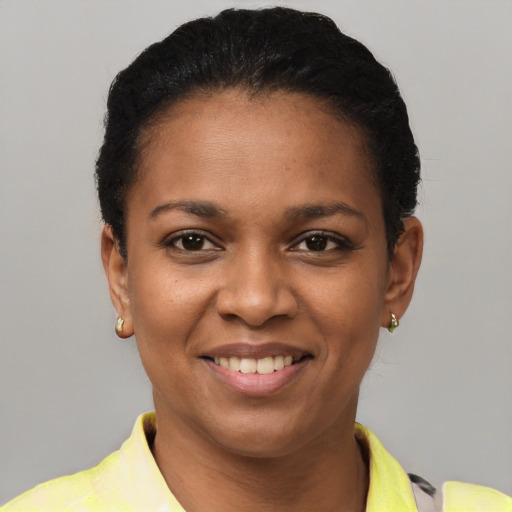 Joyful black young-adult female with short  black hair and brown eyes