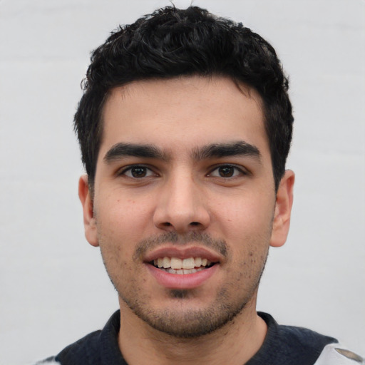 Joyful white young-adult male with short  black hair and brown eyes