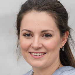 Joyful white adult female with medium  brown hair and grey eyes